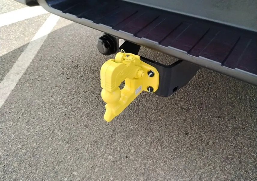 Gros plan sur le crochet d'attelage jaune fixé à l'arrière d'un pick-up Isuzu D-MAX blanc.