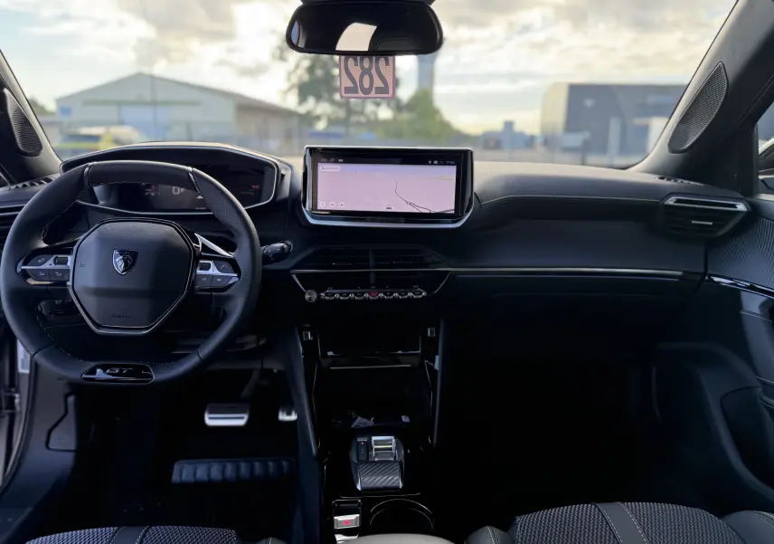 Intérieur du Peugeot 2008 Hybrid 145 GT 2026, vue frontale du tableau de bord avec écran tactile et volant compact noir.