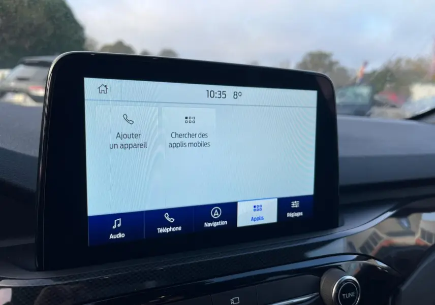 Écran tactile central du Ford Kuga 2022 affichant les options audio, téléphone, navigation et applications, intérieur noir.