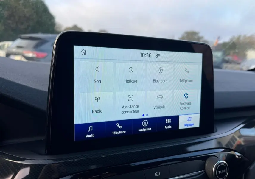Écran tactile central du Ford Kuga 2022 affichant les options audio, téléphone, navigation et réglages, intérieur moderne.