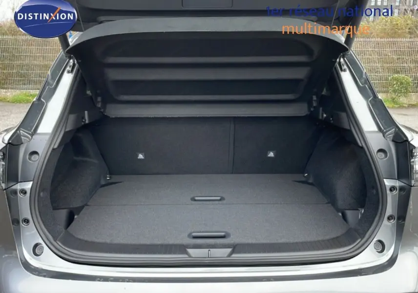 Coffre ouvert vu de l'arrière d'un Nissan Qashqai gris squale métal, montrant un espace de chargement plat et spacieux.