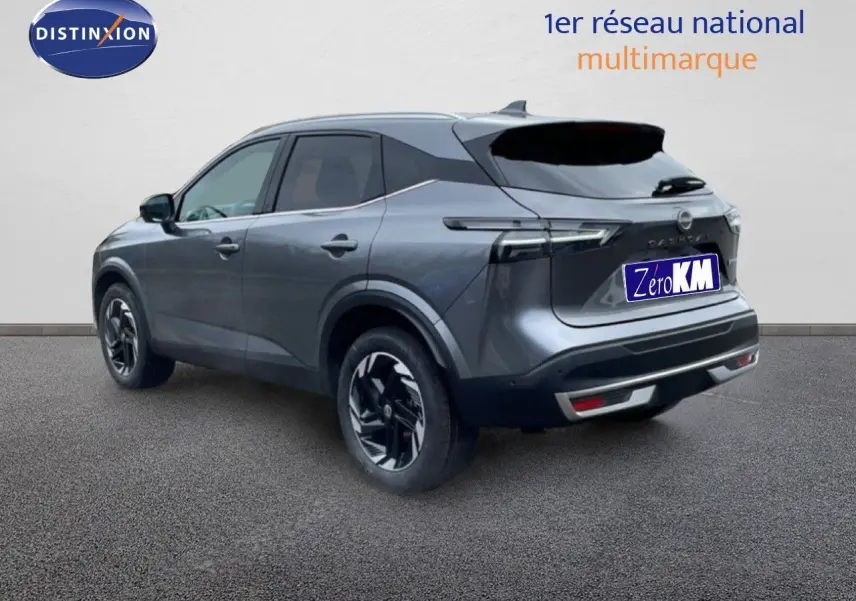 Vue 3/4 arrière droite d'un Nissan Qashqai gris squale métal 2025 avec jantes bi-ton et feux LED distinctifs.
