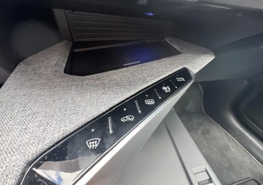 Détail de la console centrale avec commandes tactiles sur décor tissu gris clair dans un Peugeot 3008 gris titane 2024.
