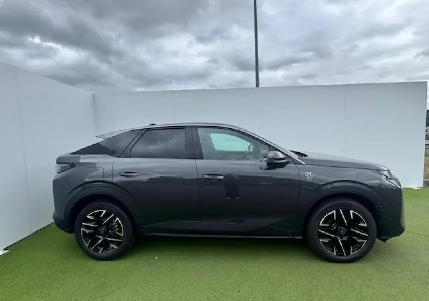 Vue de profil côté gauche d’un Peugeot 3008 gris titane avec toit noir et jantes alliage noires diamantées.