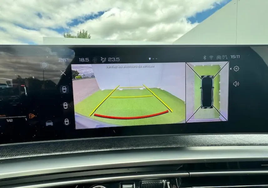 Vue de l'écran intérieur du Peugeot 3008 2024 montrant la caméra de recul et la vue à 360° du véhicule hybride gris titane.
