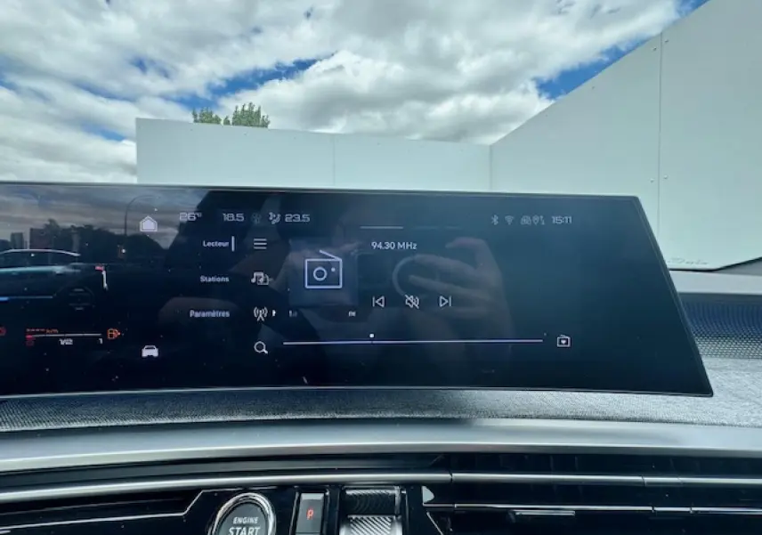 Vue intérieure centrée sur l'écran tactile du tableau de bord du Peugeot 3008 gris titane 2024 avec toit noir.