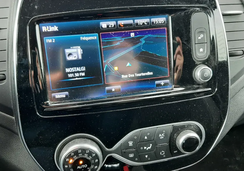 Vue rapprochée de la console centrale du Renault Captur 2017, écran tactile R-Link avec navigation et commandes de climatisation.