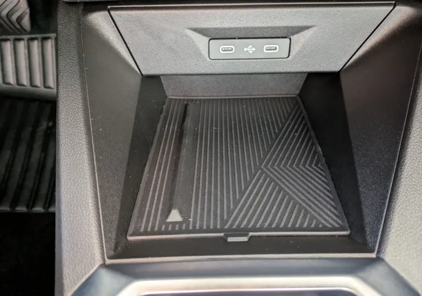 Vue rapprochée de la console centrale noire de la Renault Clio VI TCe 115ch Techno, avec ports USB et surface antidérapante.
