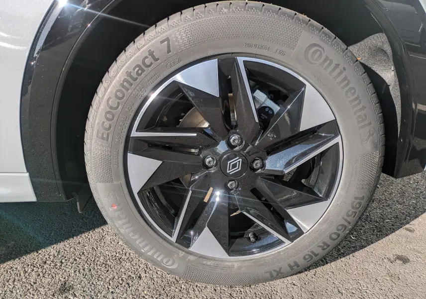 Gros plan sur la roue avant droite de la Renault Clio VI TCe 115ch Techno gris Rafale métal, jante alliage bicolore noire et argent.