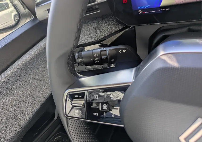 Gros plan sur le volant et la commande de clignotants d’une Renault Clio VI TCe 115ch Techno, intérieur noir.