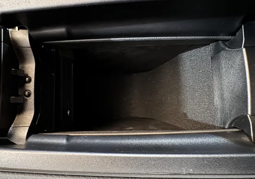 Vue plongeante sur le compartiment de rangement central intérieur du Mercedes GLA 250 e Business Line gris foncé 2023.