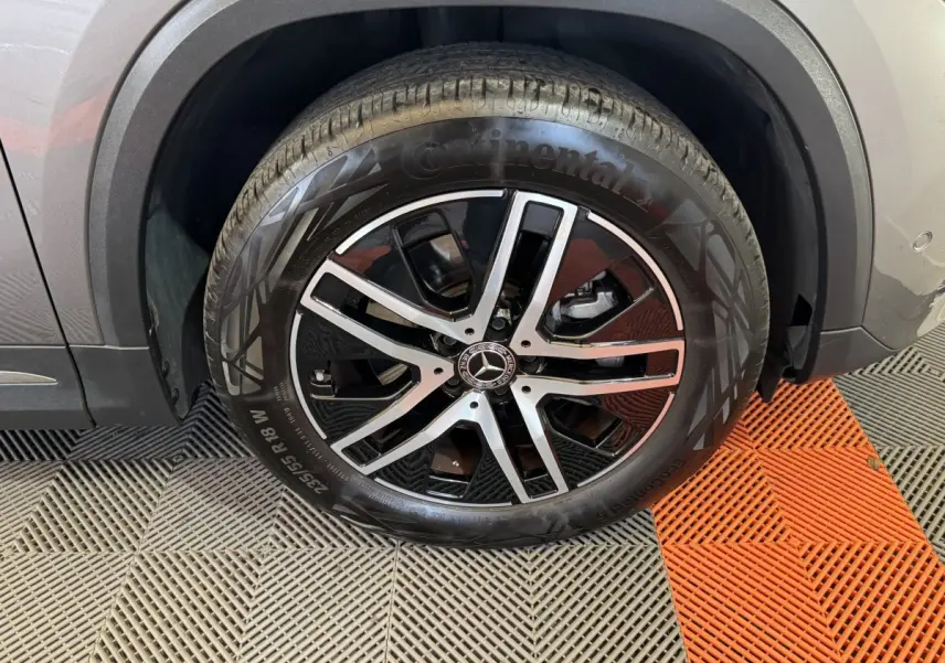 Gros plan sur la roue avant droite gris foncé d’un Mercedes GLA 250 e Business Line avec jante alliage noire et argent.