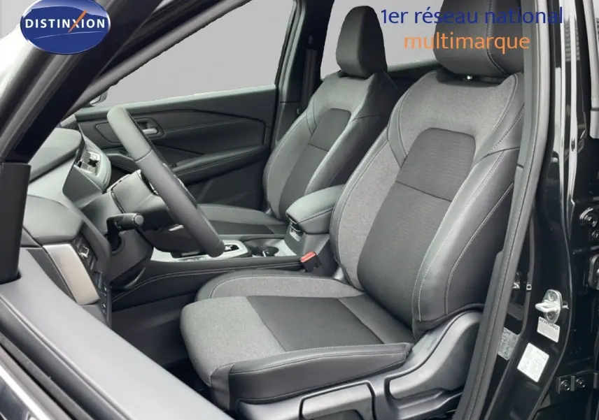 Vue intérieure côté conducteur du Nissan Qashqai noir perle métal 2025, avec sièges tissu et cuir bicolores.