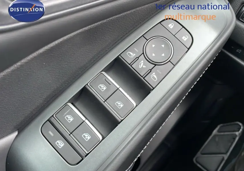 Gros plan sur les commandes de lève-vitres et rétroviseurs côté conducteur du Nissan Qashqai noir perle métal 2025.