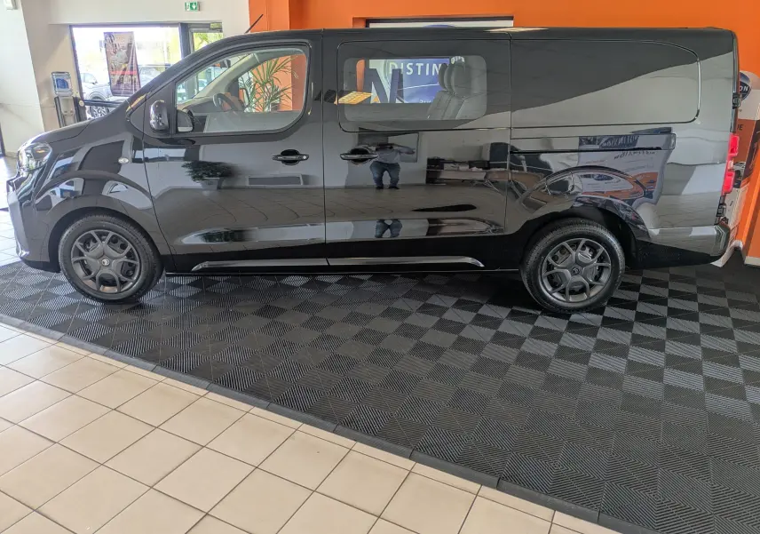 Vue de profil côté gauche d'un Citroën Jumpy Cabine Approfondie noir, avec jantes tôle noires et porte latérale coulissante.