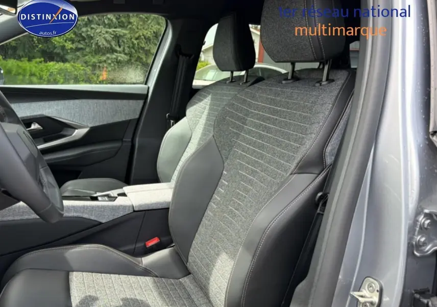 Vue intérieure côté conducteur du Peugeot 5008 gris Artense, sièges en tissu et cuir bicolore avec accoudoir central.