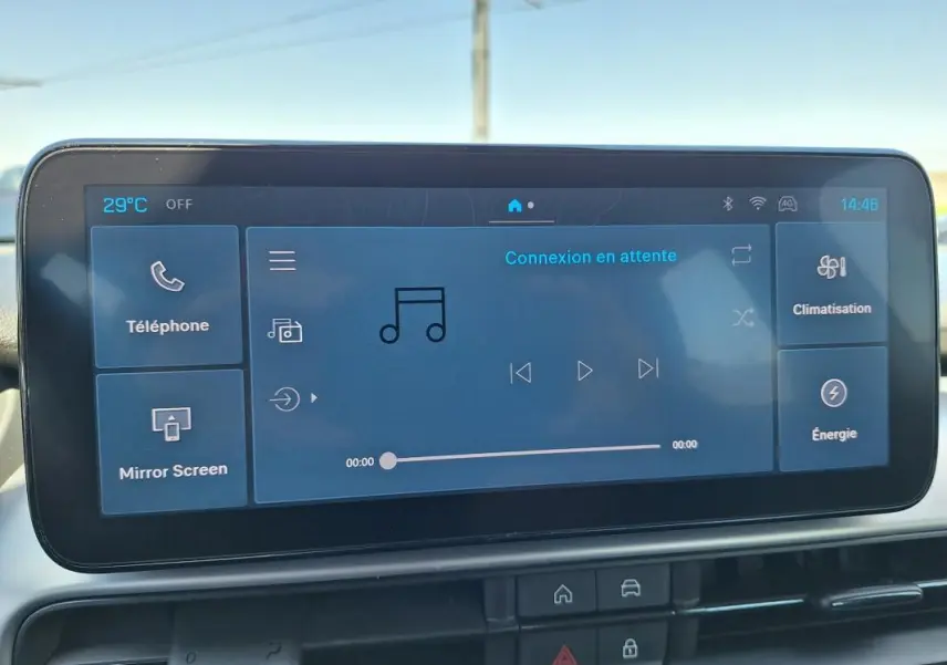 Écran tactile central du Jeep Avenger blanc, affichant l’interface multimédia avec commandes de musique et climatisation.