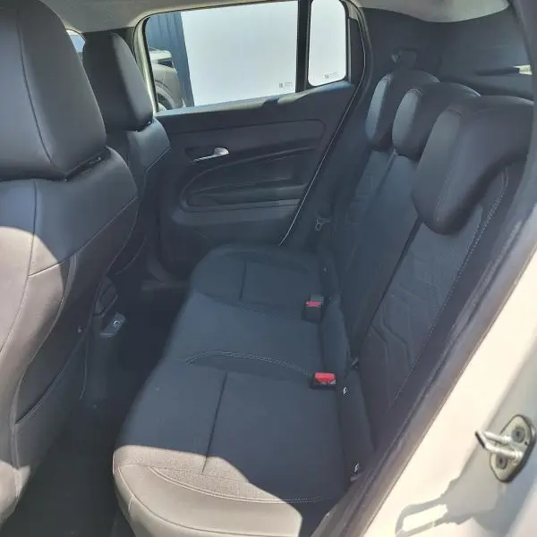 Vue intérieure côté droit des sièges arrière noirs du Jeep Avenger électrique blanc, avec appuie-têtes et ceinture de sécurité visibles.