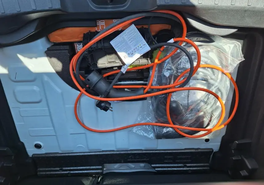 Vue du coffre du Jeep Avenger électrique blanc 2025, montrant le câble de recharge orange rangé.