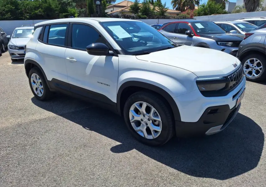 Vue 3/4 avant droit d'un Jeep Avenger électrique blanc avec jantes alliage 17 pouces et rétroviseurs noirs.