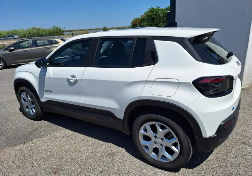 Jeep Avenger électrique blanc en 3/4 arrière droit, avec jantes alliage 17 pouces et vitres teintées.