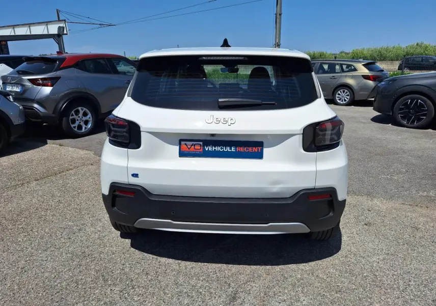Vue arrière d'une Jeep Avenger électrique blanche 2025 avec feux arrière fumés et plaque d'immatriculation "Véhicule récent".