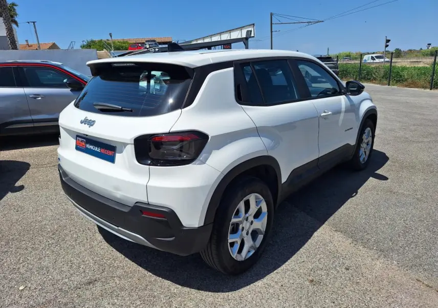 Vue 3/4 arrière droite d'un Jeep Avenger électrique blanc avec jantes alliage 17 pouces et feux arrière teintés.
