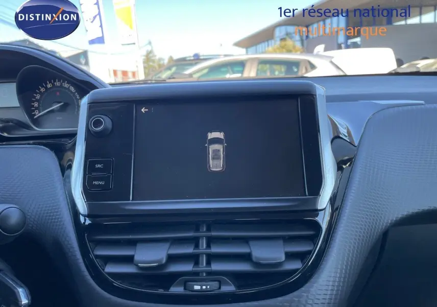 Vue rapprochée de l'écran tactile central et du tableau de bord en plastique texturé gris d'une Peugeot 2008 blanche.