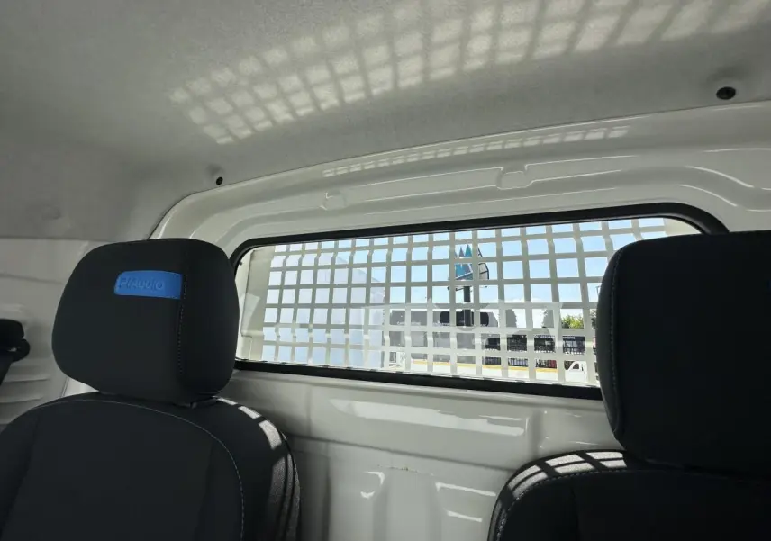 Vue intérieure arrière du Piaggio Porter blanc 2024 avec grille de séparation et sièges noirs marqués Piaggio.