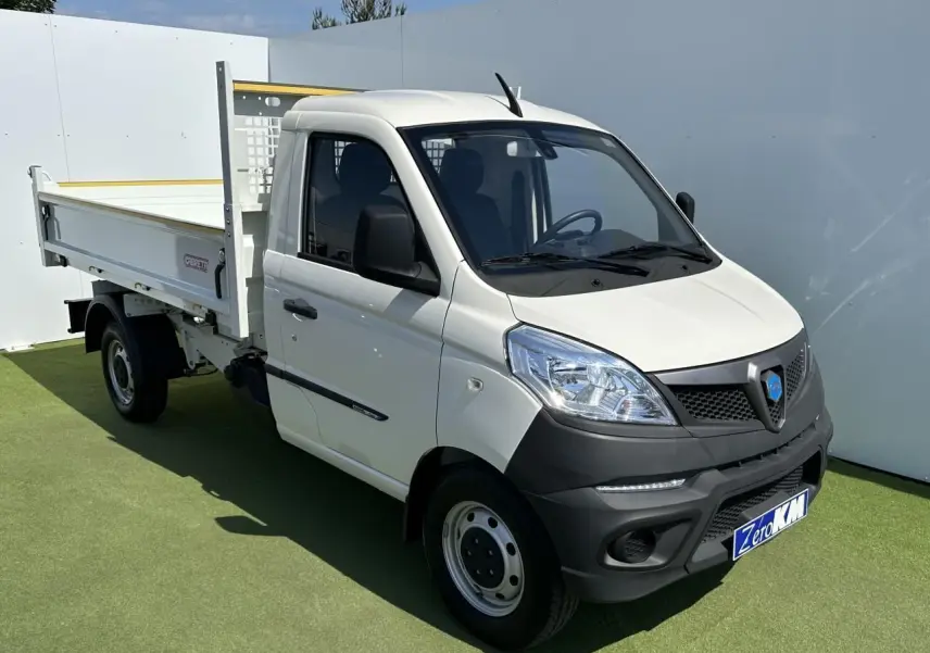 Petit utilitaire Piaggio Porter blanc vu en 3/4 avant droit avec benne longue et pare-chocs noirs contrastants.