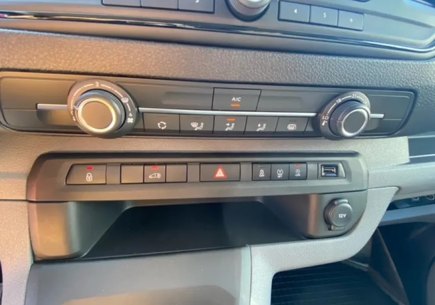 Tableau de bord du Fiat Scudo Fourgon blanc 2022, vue rapprochée des commandes de climatisation et boutons fonctionnels.