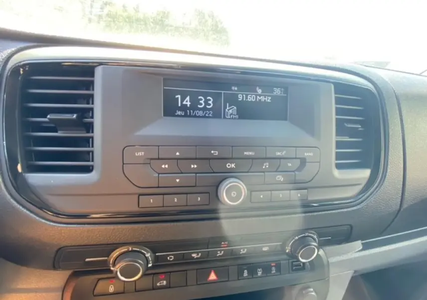 Tableau de bord du Fiat Scudo Fourgon blanc 2022, avec écran radio et commandes climatisation visibles de face.