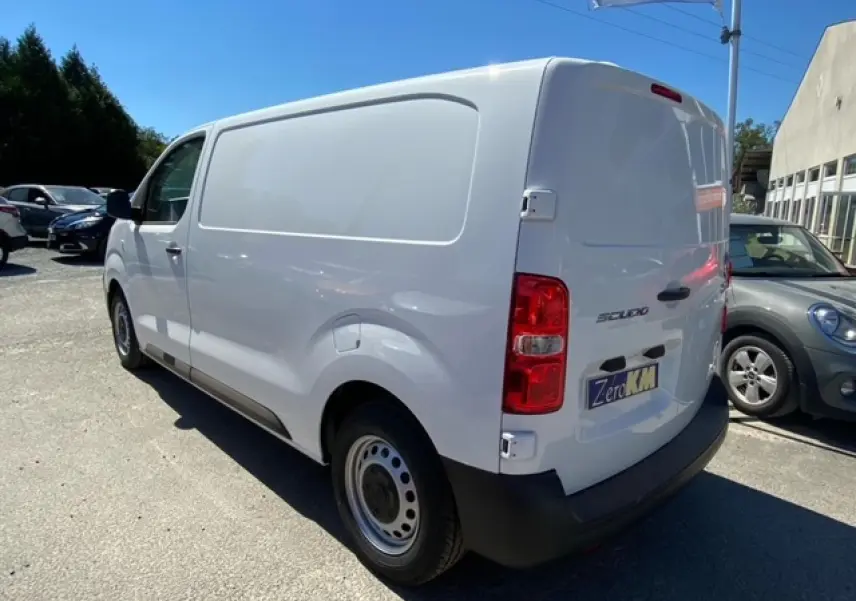 Fourgon blanc FIAT Scudo vu en 3/4 arrière droit, avec porte latérale coulissante et feux arrière rouges.