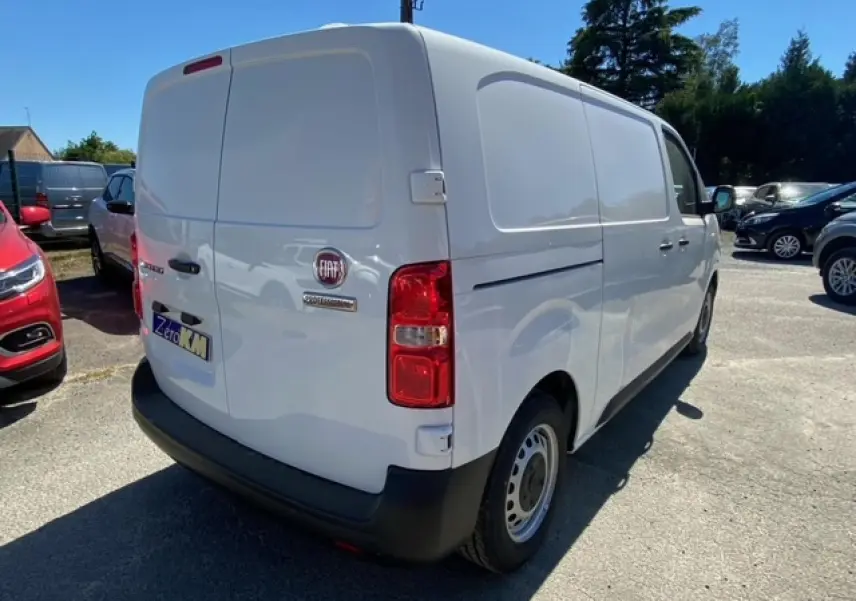 Vue 3/4 arrière droite d'un fourgon blanc FIAT Scudo 2022 avec porte latérale coulissante et feux arrière rouges.