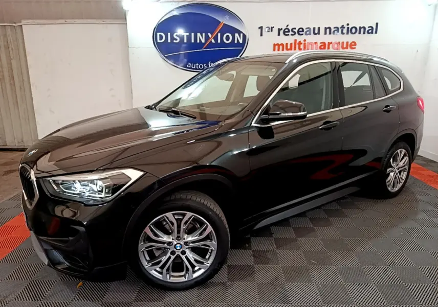 BMW X1 sDrive16d noir en 3/4 avant droit, mettant en valeur ses phares LED et ses rétroviseurs électriques chauffants.