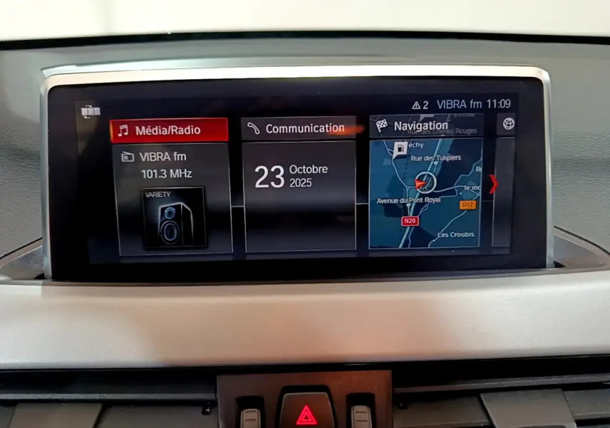 Écran multimédia central de BMW X1 sDrive16d Lounge 2021 affichant radio, communication et navigation.