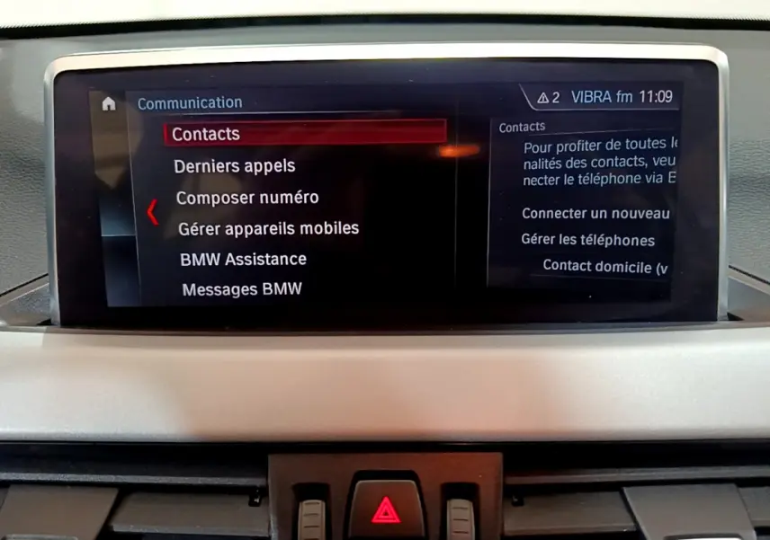 Écran central du tableau de bord de BMW X1 noir 2021 affichant le menu communication en mode contact.