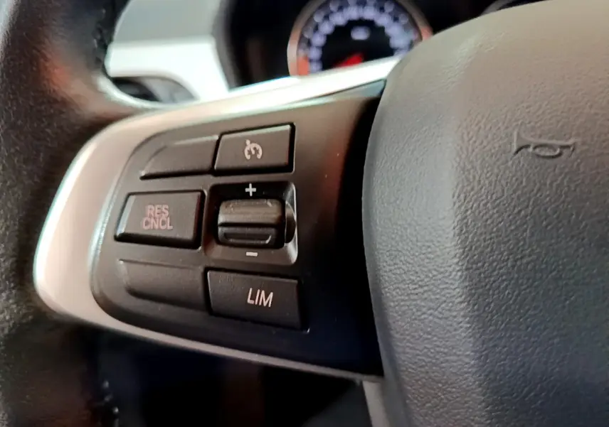 Gros plan sur les commandes de régulateur de vitesse au volant cuir noir d’un BMW X1 sDrive16d Lounge 2021.