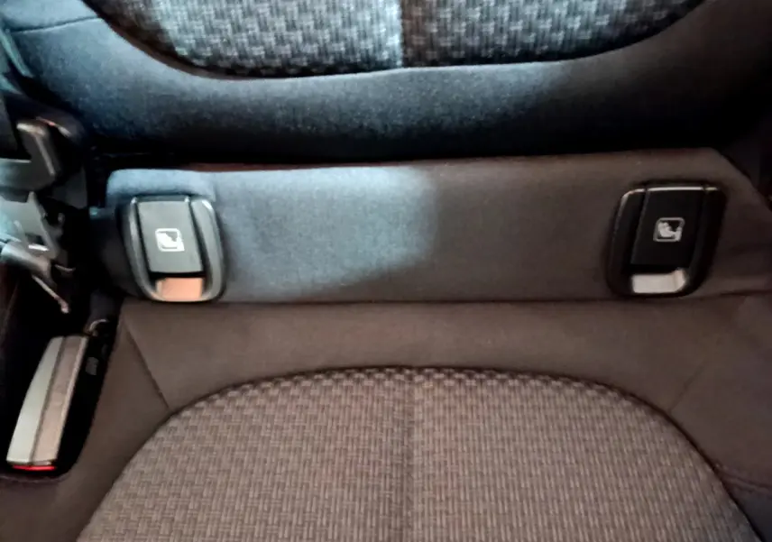 Gros plan sur la commande de rabattement des sièges arrière du BMW X1 sDrive16d Lounge noir, détail intérieur.