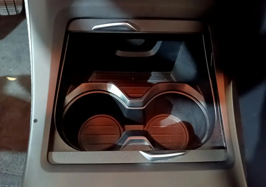 Gros plan sur les porte-gobelets noirs intégrés à la console centrale du BMW X1 sDrive16d Lounge DKG7 2021.