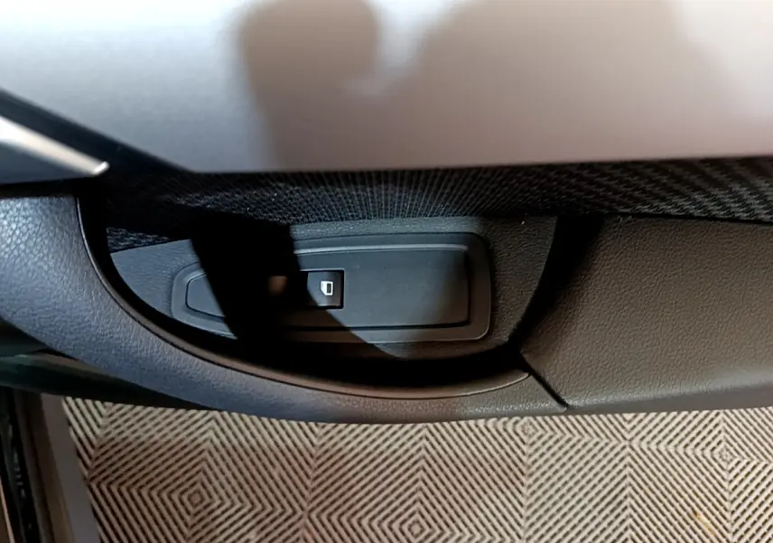 Gros plan sur le bouton de verrouillage centralisé dans la portière côté conducteur d’un BMW X1 noir 2021.