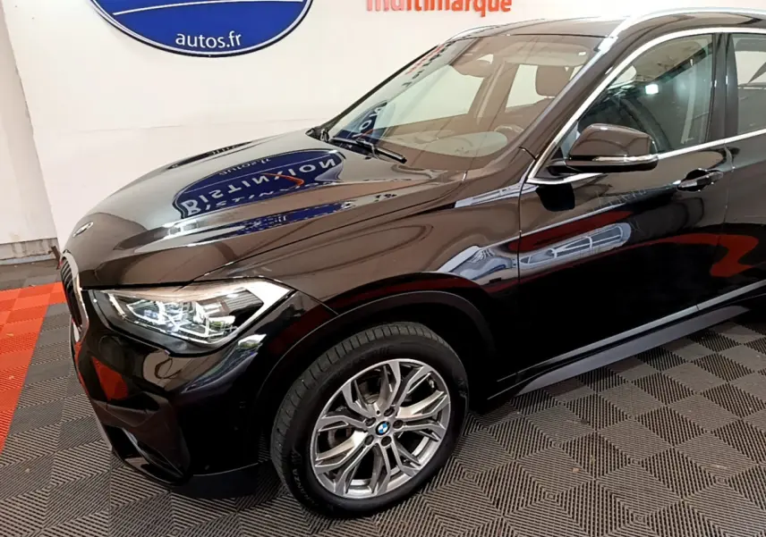 BMW X1 sDrive16d noir en 3/4 avant droit, mettant en valeur ses phares LED et jantes alliage.