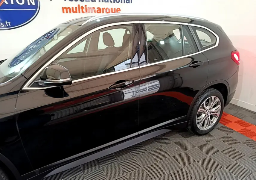 Vue latérale droite d'un BMW X1 noir 2021 avec jantes alliage et rétroviseurs noirs brillants.