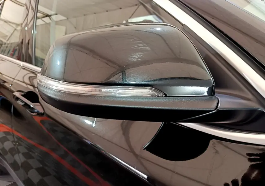 Gros plan sur le rétroviseur côté gauche noir brillant du BMW X1 sDrive16d Lounge 2021 avec clignotant intégré.