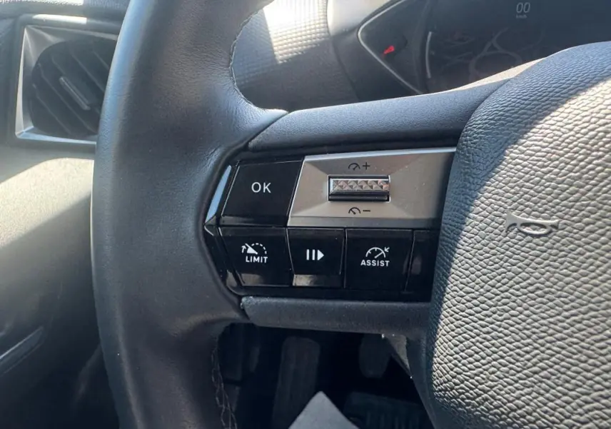 Gros plan sur le volant noir de la DS3 100 BVM6 Bastille 2024, montrant les commandes de régulateur et limiteur de vitesse.