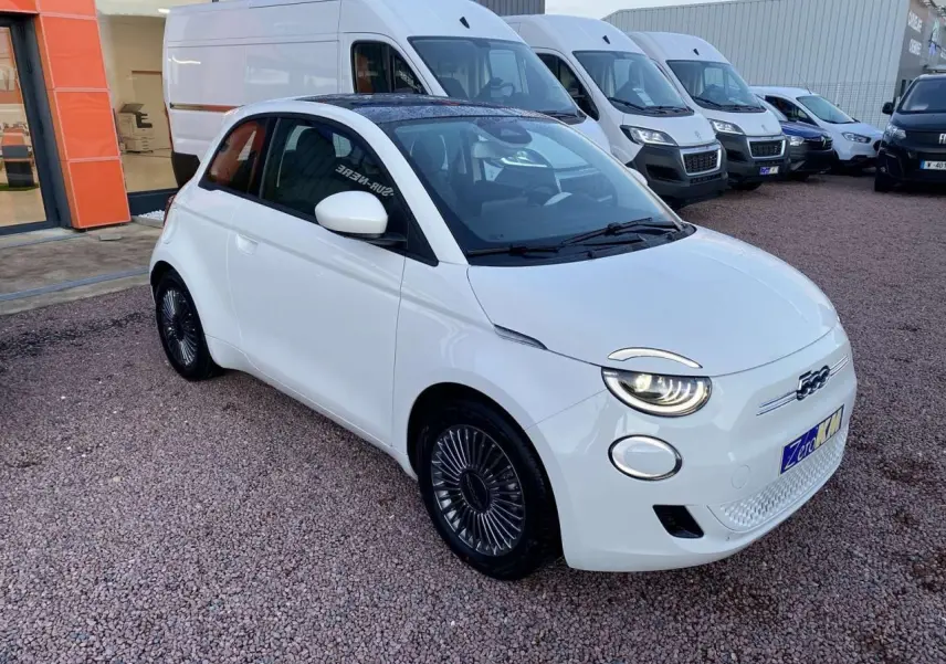 Fiat 500 électrique blanche vue 3/4 avant droit, avec jantes alliage 16 pouces Icône et toit panoramique noir.