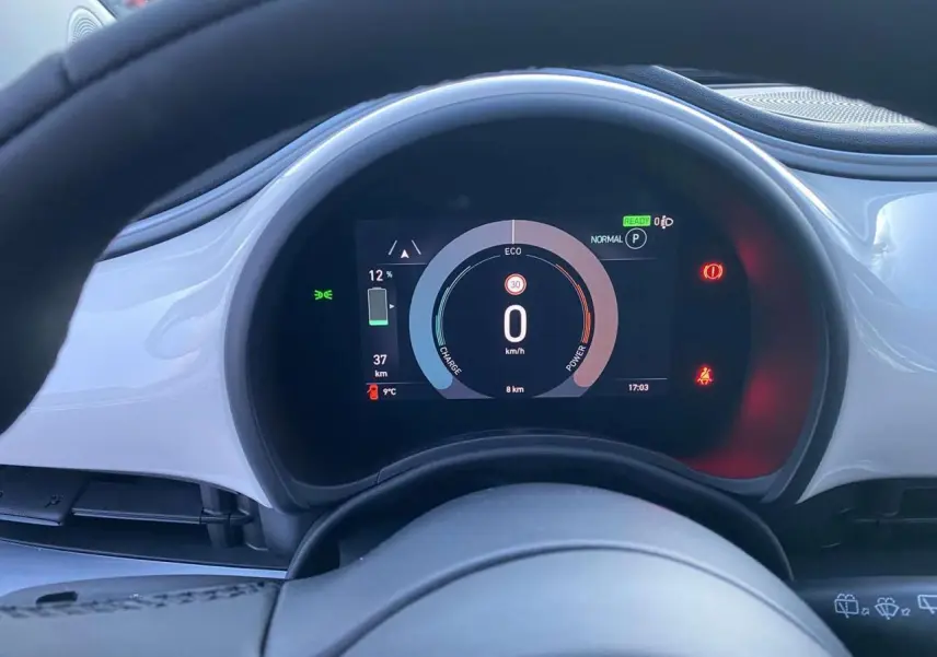 Tableau de bord numérique de la FIAT 500 électrique blanche 2022, affichant vitesse zéro et autonomie restante.