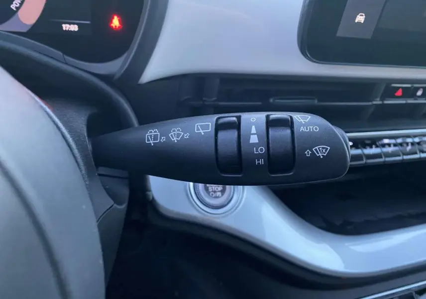 Gros plan sur la commande d'essuie-glace côté droit du tableau de bord blanc d'une Fiat 500 électrique 2022.