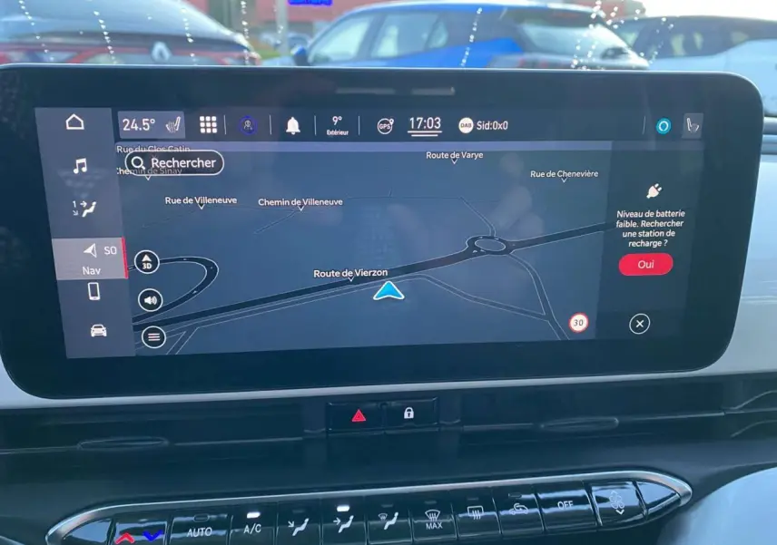 Écran tactile central du tableau de bord du Fiat 500 électrique blanc, affichant la navigation GPS en plein jour.