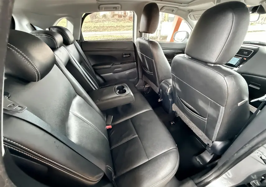 Vue intérieure arrière du Mitsubishi ASX 2015 montrant les sièges en cuir noir avec accoudoir central déployé.